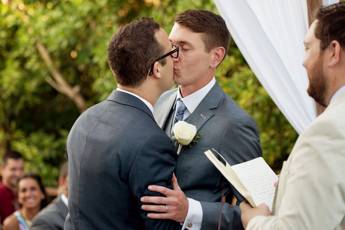 Grooms kiss at Paradisus Playa del Carmen destination wedding in Mexico by Martina Campolo Photography