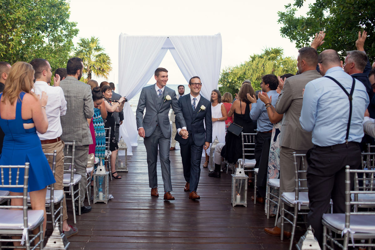 Groom and groom ceremony exit by Martina Campolo LGBT Wedding Photography in Riviera Maya, Mexico