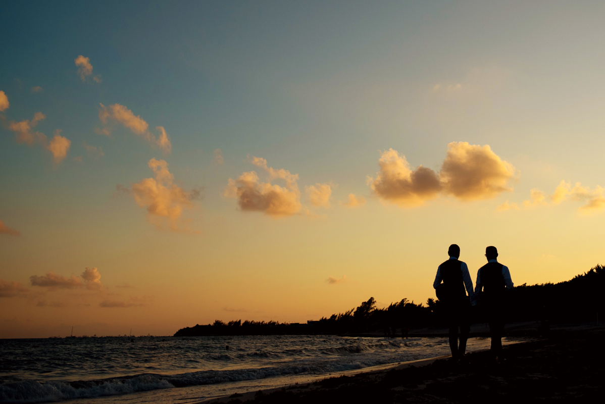 Groom and groom silhouettes at sunset in Playa del Carmen, Mexico. Martina Campolo Photography