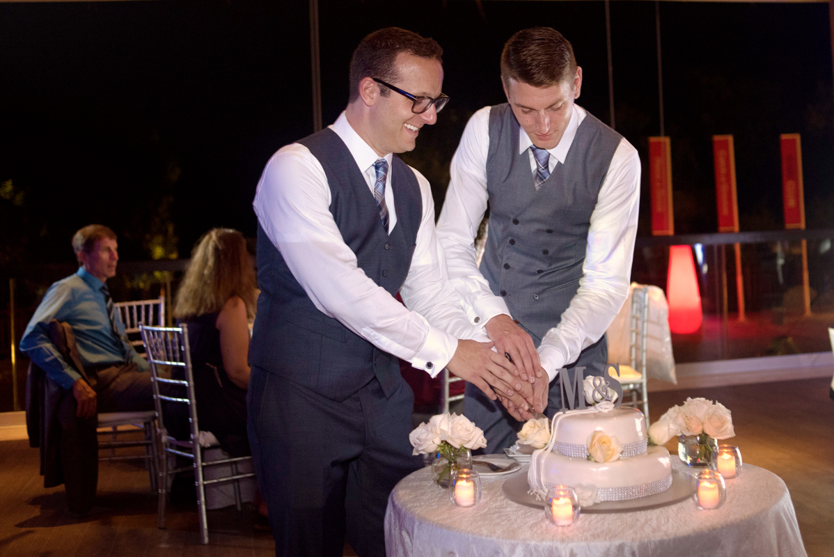 Cake cutting moment between groom at Paradisus Playa del Carmen, Mexico. Martina Campolo LGBTQ Wedding Photography