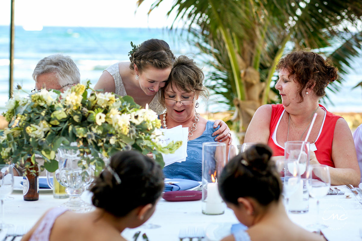 Destination bride hugs guests at wedding reception table. Hacienda del Mar, Riviera Maya, Mexico. Martina Campolo Photography